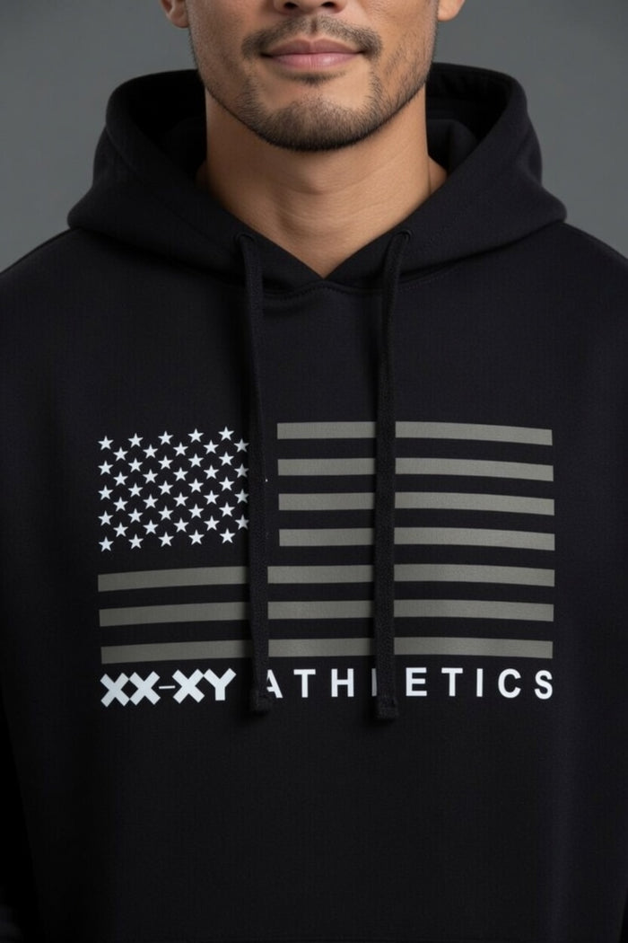 Person wearing a black hoodie with an American flag design and 'XXXY Athletics' text. || Black