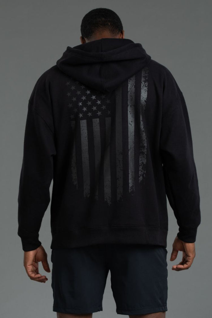 Person wearing a black hoodie with an American flag design on the back || Black