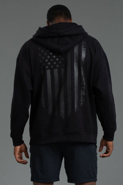 Person wearing a black hoodie with an American flag design on the back || Black