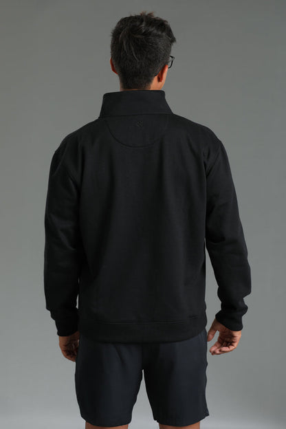 Person wearing a black jacket and shorts on a gray background || Black