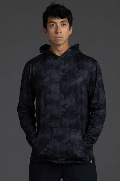 Person wearing a dark camouflage hoodie on a gray background || Black Camo