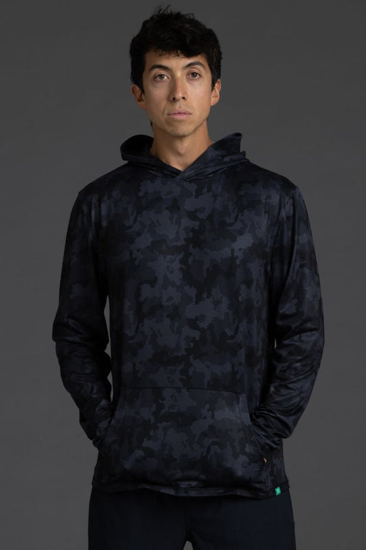 Person wearing a dark camouflage hoodie on a gray background || Black Camo