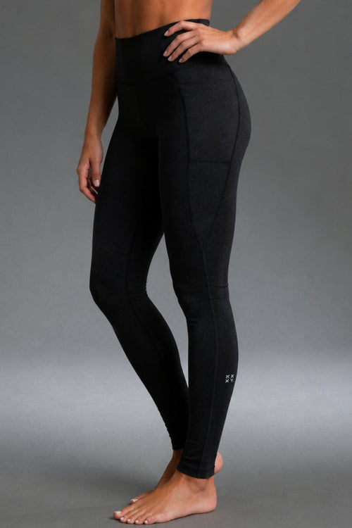 A model wearing black high-waisted athletic leggings with a side pocket, shown from the waist down against a neutral gray studio background. || Black Heather